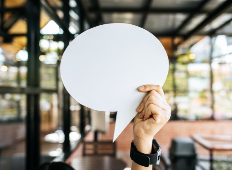 hand holding paper speech bubble