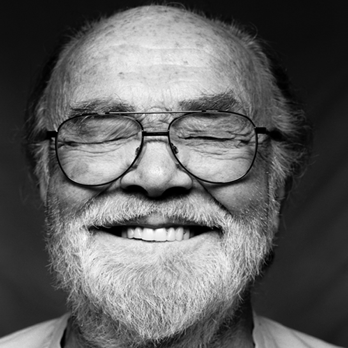Man with eyes closed wearing glasses smiling. Image in black and white