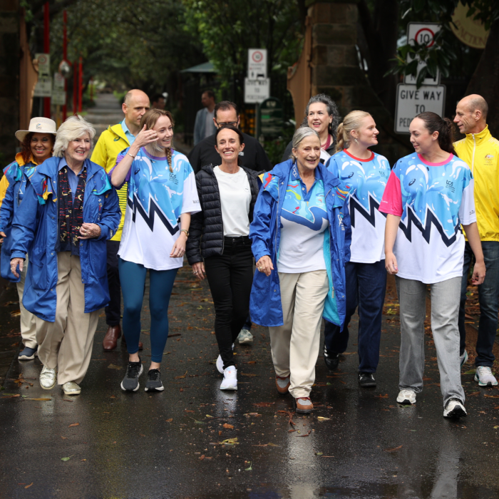 A group of people walking down the street in blue and yellow clothing