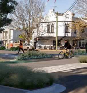 Man riding bike on cycleway and pedestrian crossing on cross walk on West Street