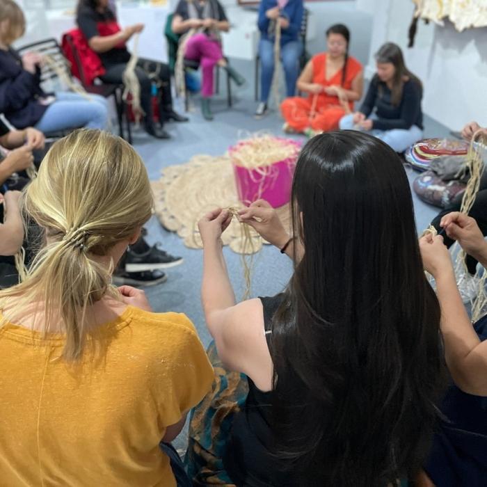 people sitting in circle weaving