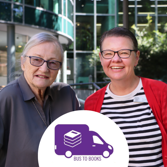 Image of a user of Bus to Books with staff member standing in front of Stanton Library smiling.