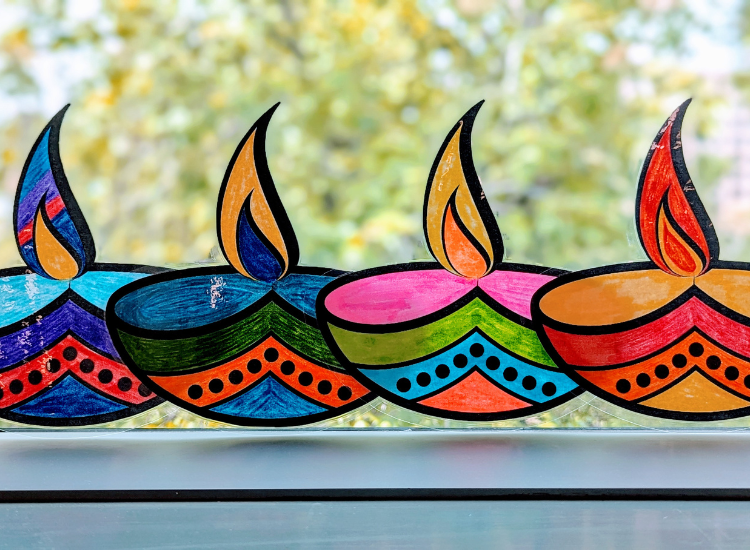 Photo of 4 brightly decorated diyas lined up next to each other