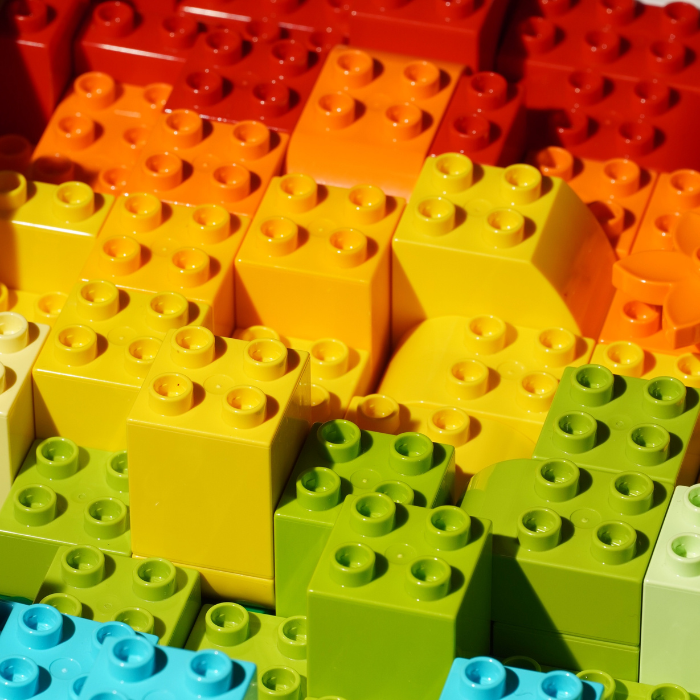 Large LEGO duplo pieces stacked in rainbow colours.