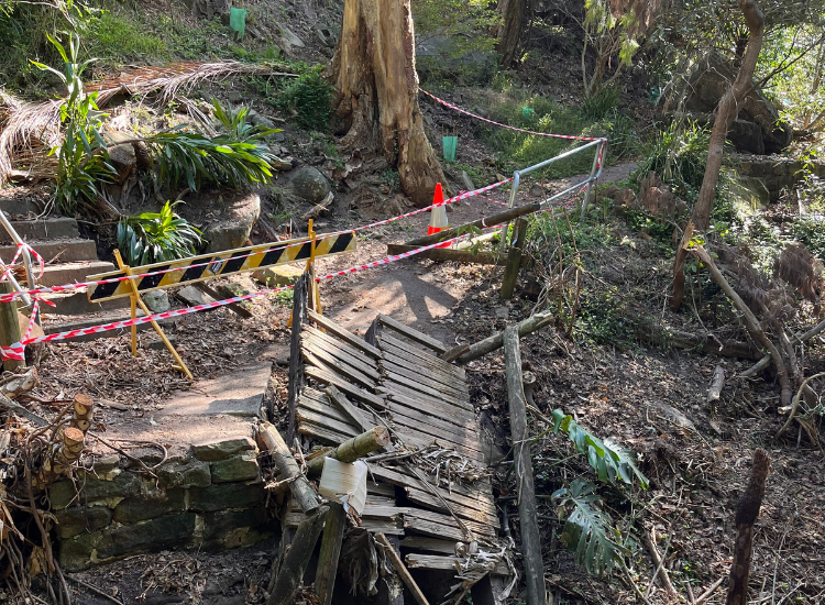 A damaged footbridge with caution tape around it