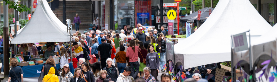 crowd of people in the north sydney cbd with market stalls along the street