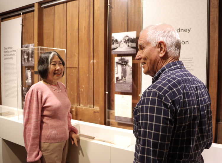 A woman and a man standing in front of a local history display.