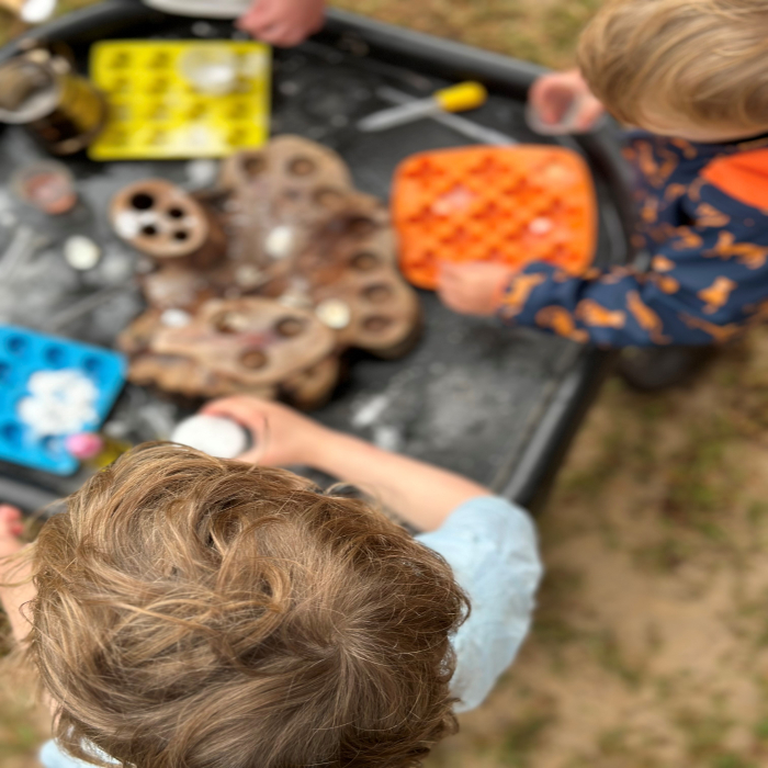 Small children playing with toys outside