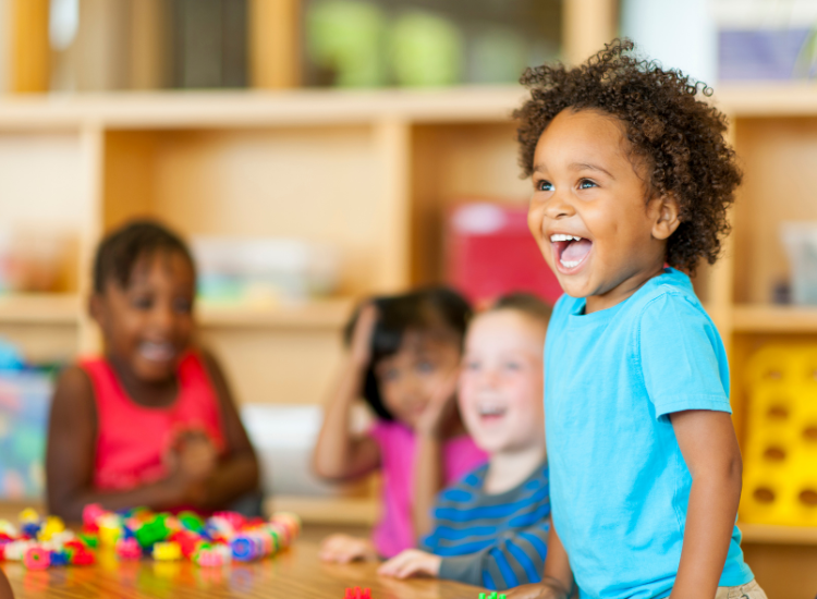 Child smiling at a school table