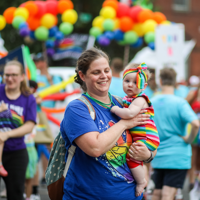 Image of a mother and baby wearing pride rainbow clothes.