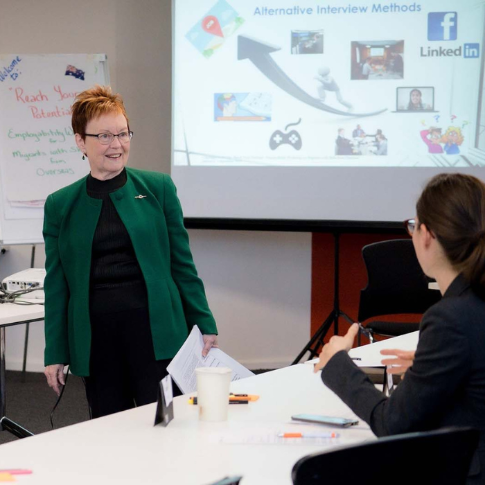 Presenter talking to a woman during a workshop