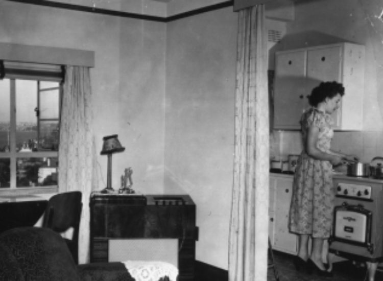 A black and white photo of Mrs Irene Leper in her kitchen, Greenway Flats, Milsons Point, 1953