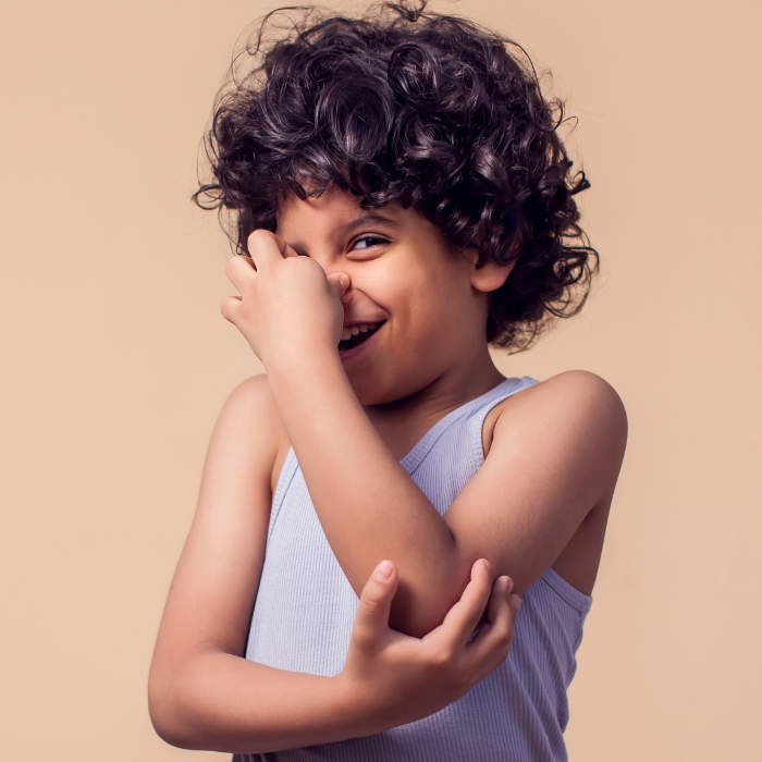 A child holding his nose and laughing