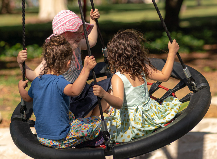 Three small children on a swing