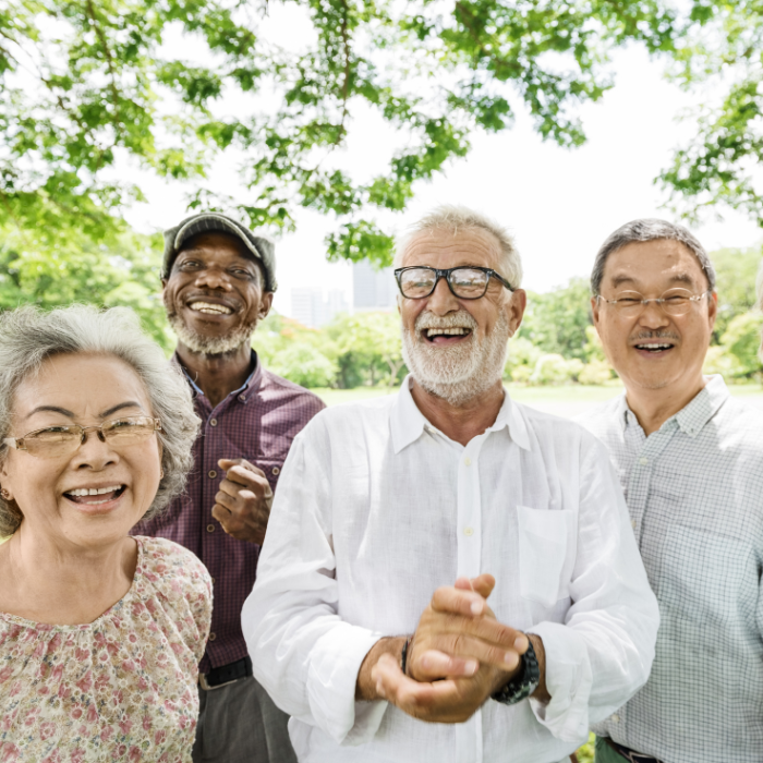 A group of seniors smiling together, including an Asian lady, black man, Caucasian white man and Asian man.