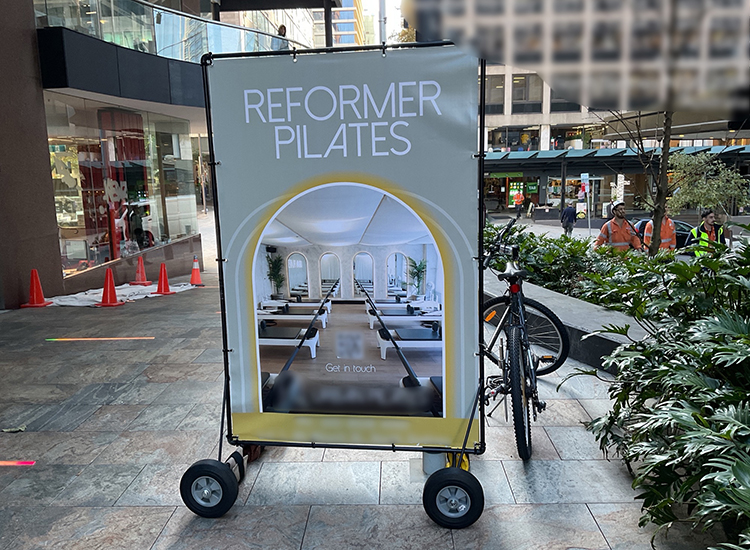 Sign on wheels attached to a bicycle in Elizabeth Plaza North Sydney