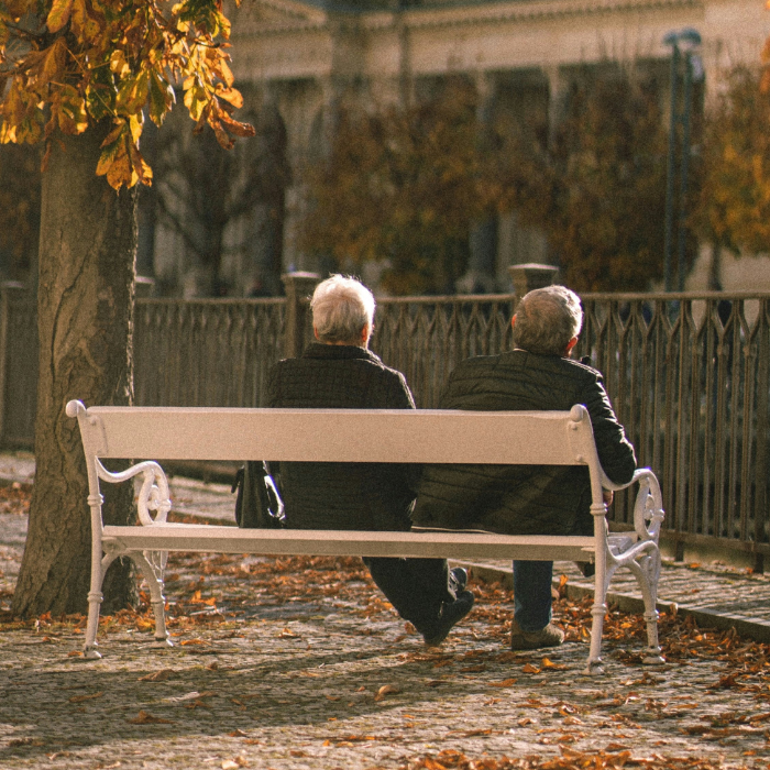 Two seniors sitting on a bench together