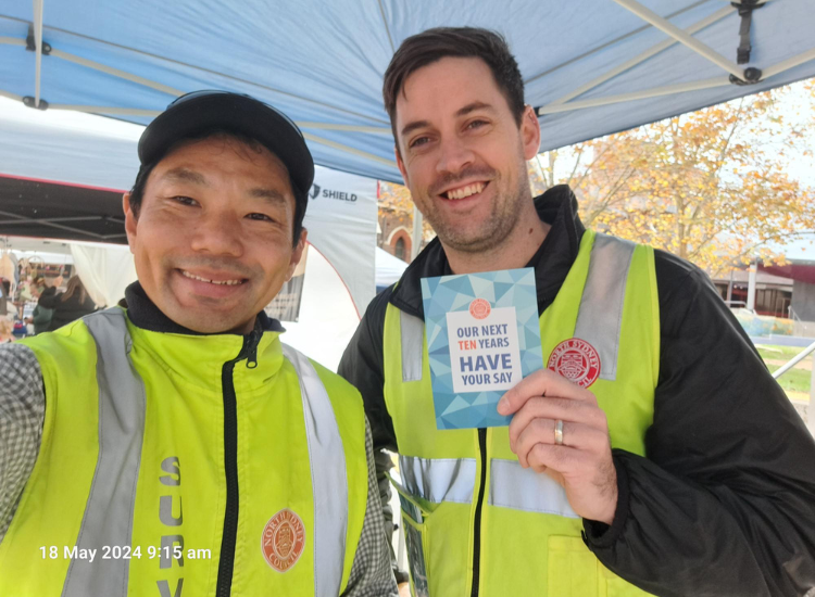 Selfie image of two men in high vis vests smiling