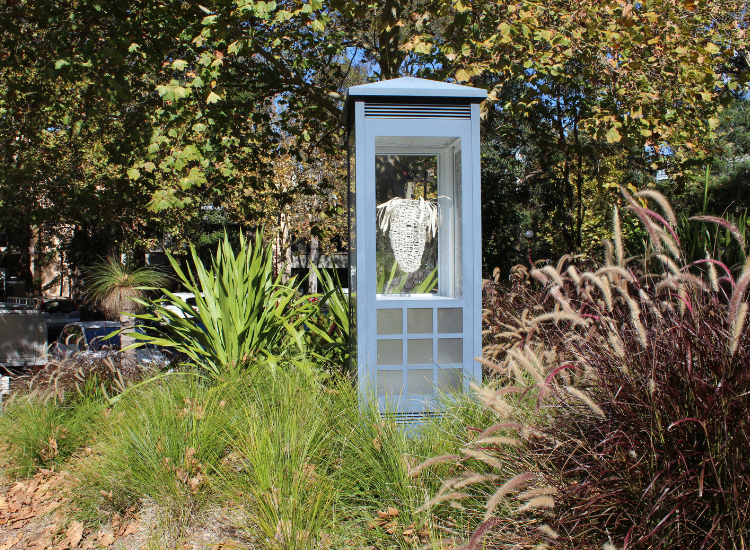 Grey sculpture plinth in landscaped setting