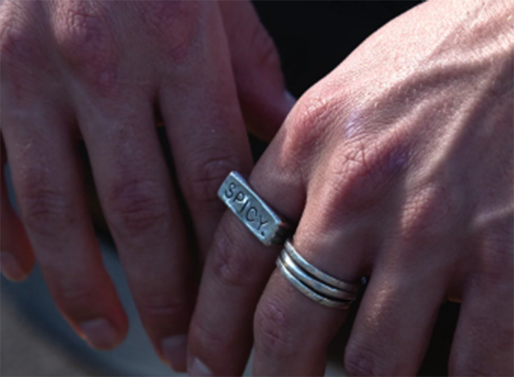 close up of hands wearing two silver rings