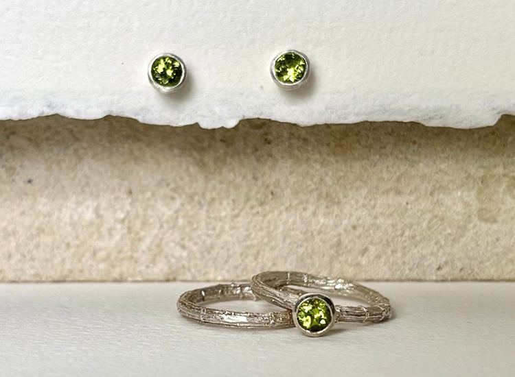 two rings with green gemstone with matching studded earrings