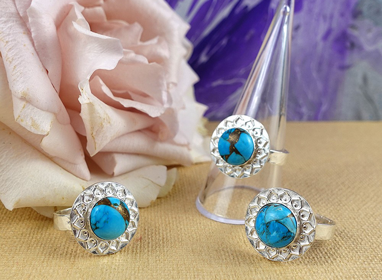 three silver rings with blue gem in middle