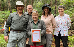 Sissi Stewart holding her Living Legend Award with fellow Bushcare volunteers